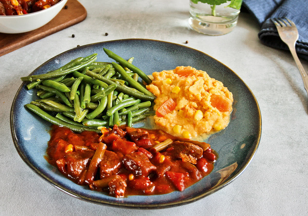 Rindergulasch Barbeque mit grünen Bohnen und Kartoffel-Süßkartoffel-Stampf